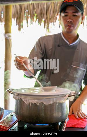 Chef e tutor dimostrano come cucinare la carta di riso utilizzata per panini e spaghetti presso la scuola di cucina Red Bridge alla periferia di Hoi An, in Vietnam. Foto Stock