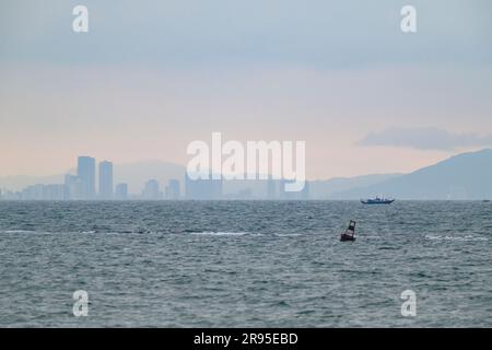 Vista sulla baia del Mare del Vietnam orientale fino allo skyline di da Nang dalla spiaggia di Hoi An, Vietnam. Foto Stock