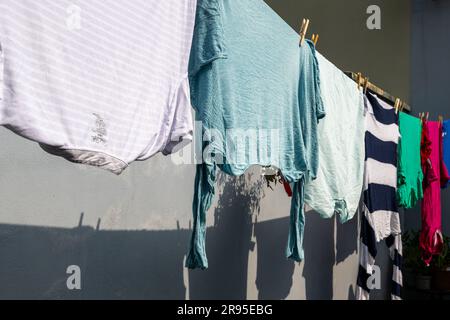 Gli indumenti si asciugano al sole su una linea di lavaggio. Foto Stock