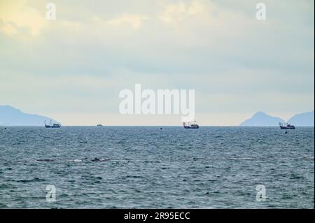 Barche da pesca che attraversano le acque tra la spiaggia di Hoi An e le isole Cham nel Mare del Vietnam orientale, Vietnam. Foto Stock