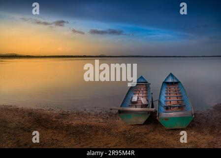 Barche nel serbatoio al crepuscolo con cielo colorato in Thailandia Foto Stock