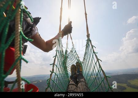 Soccorso da terreni difficili da raggiungere. Paciente in barella a rete con medico sono appesi su corda sotto elicottero servizio medico di emergenza. Foto Stock