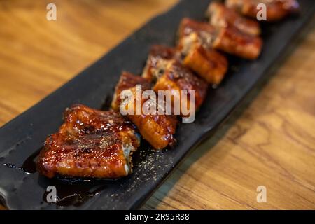 Sliced Unagi. Anguilla grigliata con salsa servita sul piatto Foto Stock