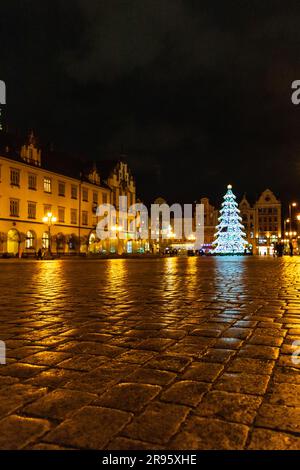 Breslavia, Polonia - gennaio 2023: Piazza del mercato di Breslavia di notte con alcune persone che camminano, lanterne scintillanti e un'altezza luminosa splendidamente e colorata Foto Stock