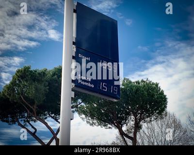 Una segnaletica che mostra i prezzi della benzina e del diesel in euro, sullo sfondo sereno di un albero e cielo azzurro Foto Stock