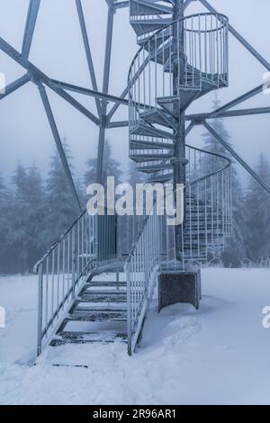 Klodzko, Polonia - gennaio 2023: Costruzione in metallo di scale a spirale della torre di osservazione in cima al monte Klodzka Foto Stock