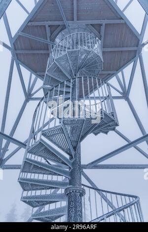 Klodzko, Polonia - gennaio 2023: Costruzione in metallo di scale a spirale della torre di osservazione in cima al monte Klodzka Foto Stock