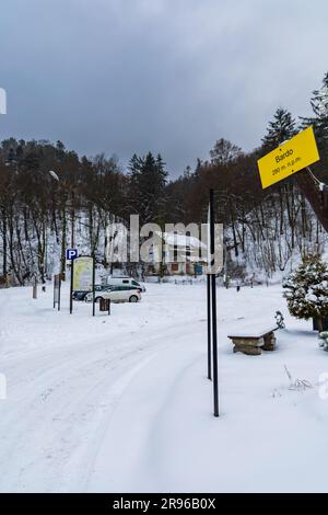 Bardo, Polonia - gennaio 2023: Punto di riferimento montano nella città di Bardo, con un piccolo albero e un cartello giallo appeso accanto al parcheggio Foto Stock