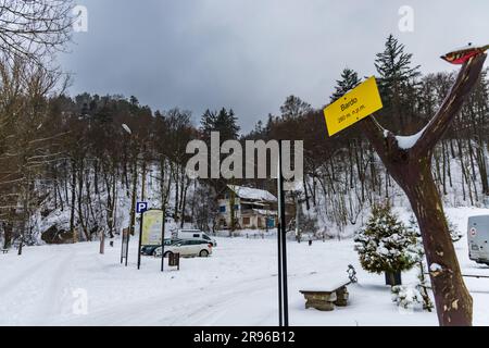 Bardo, Polonia - gennaio 2023: Punto di riferimento montano nella città di Bardo, con un piccolo albero e un cartello giallo appeso accanto al parcheggio Foto Stock