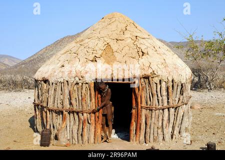 Himba di fronte alla capanna di fango, Kaokoland, Himbaland, Namibia Foto Stock