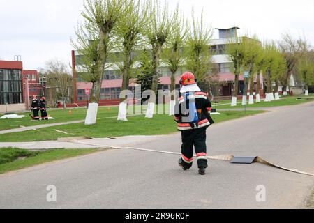 Vigili del fuoco professionisti, soccorritori in tute protettive antincendio, caschi e maschere a gas con bombole di ossigeno sono pronti a salvare le persone da pericoli Foto Stock