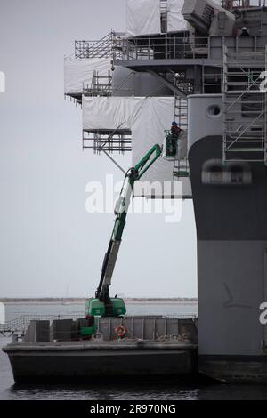 230622-N-ML799-1121 SAN DIEGO (22 giugno 2023) – i marinai assegnati alla portaerei d'assalto anfibio USS Tripoli (LHA 7) utilizzano un sollevatore per dipingere lo scafo della nave durante la disponibilità di manutenzione della nave il 22 giugno. Tripoli è una nave d'assalto anfibio di classe americana, con base a San Diego. (STATI UNITI Foto Marina militare di Mass Communication Specialist 3rd Class Olivia Rucker) Foto Stock