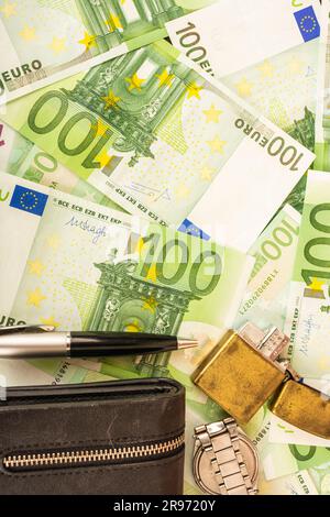 pennarello orologio con borsetta oro più leggero sullo sfondo di banconote da 100 euro a moneta verde Foto Stock