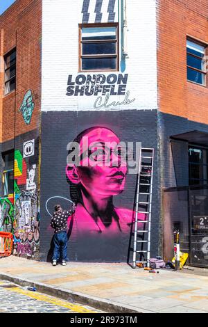 David Speed dipinge un ritratto al neon su Ebor Street, Shoreditch High Street, Londra, Inghilterra Foto Stock