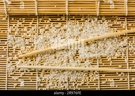 le bacchette di sushi-tappeto e il riso sono sul tavolo Foto Stock