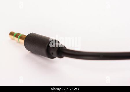 il jack per cuffie da 3,5 mm con cavo è posizionato su uno sfondo bianco isolante Foto Stock