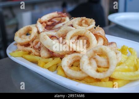 Calamari fritti e patatine fritte in un ristorante spagnolo Foto Stock