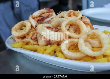 Deliziosi calamari fritti e patatine fritte in un ristorante spagnolo Foto Stock