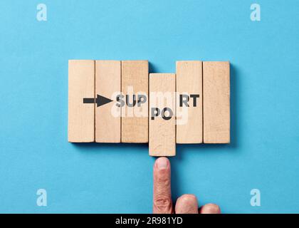 Supporto e assistenza aziendale. Mano maschio che spinge i blocchi di legno con la parola support. Foto Stock