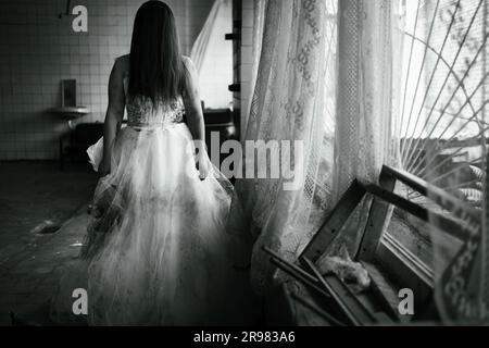 Scena horror di una donna spaventosa che sposa un fantasma in un edificio abbandonato in rovina Foto Stock