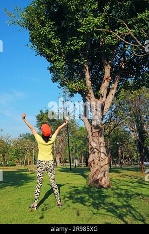 Donna attiva che si allunga alla luce del sole del mattino Foto Stock