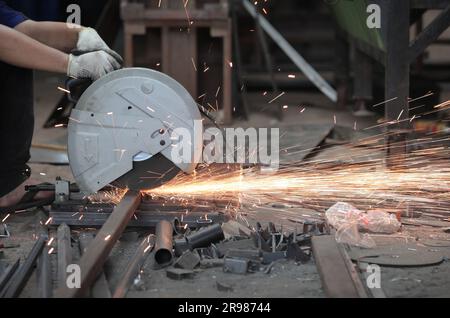 Giacarta, Indonesia - 20 giugno 2023 : tagliare la piastra di ferro con una smerigliatrice Foto Stock