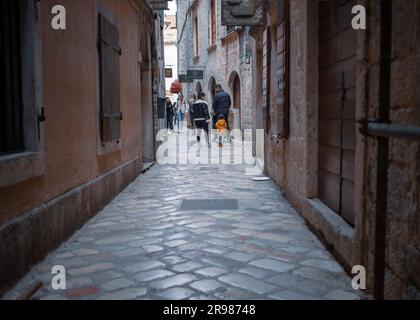 Montenegro, aprile 2023: Vista di una tipica strada acciottolata della città vecchia di Cattaro Foto Stock