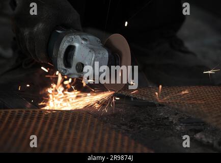 Giacarta, Indonesia - 20 giugno 2023 : tagliare la piastra di ferro con una smerigliatrice Foto Stock