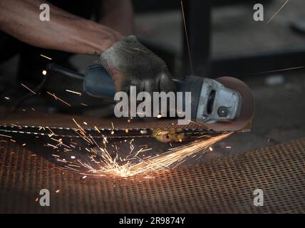 Giacarta, Indonesia - 20 giugno 2023 : tagliare la piastra di ferro con una smerigliatrice Foto Stock