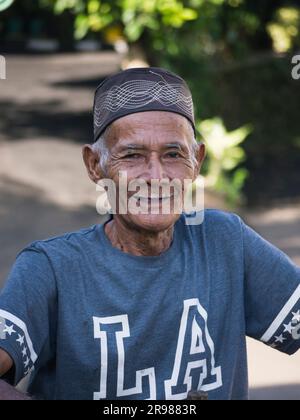 Giacarta, Indonesia - 20 giugno 2023: Ritratto di un uomo anziano asiatico che indossa un cappello nero con capelli grigi sorridenti davanti alla fotocamera Foto Stock