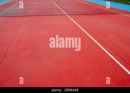 al netto di un campo da tennis rosso vuoto Foto Stock