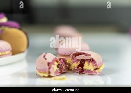 Un assortimento di macaron appena fatti disposti su un tavolo bianco Foto Stock