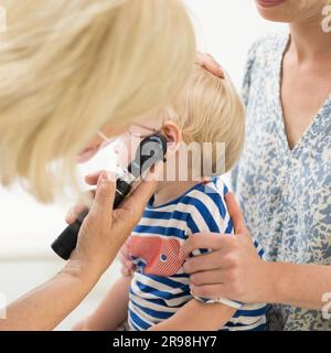 Bambino bambino bambino bambino in esame dal suo medico pediatra durante un controllo medico standard in presenza e comfort di sua madre. Sanità pubblica nazionale e cura dei bambini koncept Foto Stock