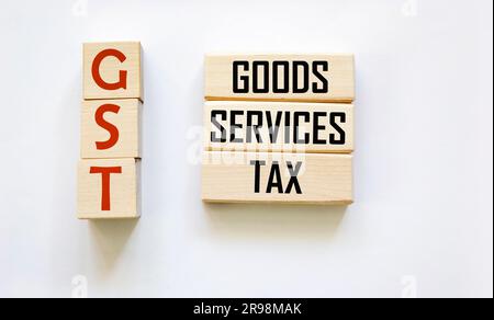 Lettere alfabetiche GST su blocchi di legno, messaggi FISCALI GST su blocchi di legno E su sfondo bianco Foto Stock