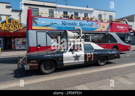 Southend on Sea, Essex, Regno Unito. 25 giugno 2023. La gente è fuori a godersi la calda mattinata di sole nella città di mare. Autobus scoperto Seaside Service che corre lungo il lungomare passando per una copia dell'auto della polizia Blues Brothers Foto Stock