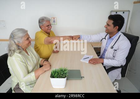 la madre sta aspettando un bambino. Giovane paziente con marito che viene controllato da ginecologo anziano durante la consultazione Foto Stock