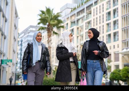 Giovani donne musulmane con hijab che camminano. Giovani amici musulmani che escono insieme Foto Stock