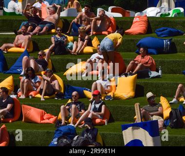 Londra, Regno Unito. 25 giugno 2023. La gente prende il sole su sacchetti di fagioli accanto a giganti "ghiaccioli che si sciogliano" sull'erba artificiale di Granary Square, King's Cross, mentre le temperature aumentano nella capitale. Credito: Vuk Valcic/Alamy Live News Foto Stock