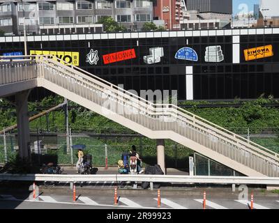 TOKYO, GIAPPONE - 16 giugno 2023: Veduta della passerella pedonale nell'area di Harajuku a Tokyo con un edificio che ospita una mostra Rimowa, 'SEIT 1898'. Foto Stock