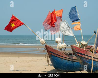 Tradizionali barche da pesca vietnamite spiaggiate sulla spiaggia di Sam Son, provincia del Vietnam di Thanh Hoa. Foto Stock