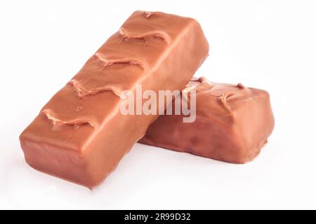 Le tavolette di cioccolato si trovano una sopra l'altra, isolate su bianco Foto Stock