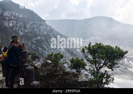 Bandung, Indonesia. 25 giugno 2023. Un turista guarda il cratere del vulcano Tangkuban Parahu, nella Reggenza di Bandung, Giava Occidentale, Indonesia, il 25 giugno 2023. Uno dei vulcani di Giava Occidentale, il Monte Tangkuban Perahu attrae l'interesse sia dei turisti locali che stranieri durante le vacanze del fine settimana. (Foto di Dimas Rachmatsyah/INA Photo Agency/Sipa USA) credito: SIPA USA/Alamy Live News Foto Stock