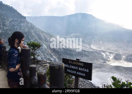 Bandung, Indonesia. 25 giugno 2023. Un turista guarda il cratere del vulcano Tangkuban Parahu, nella Reggenza di Bandung, Giava Occidentale, Indonesia, il 25 giugno 2023. Uno dei vulcani di Giava Occidentale, il Monte Tangkuban Perahu attrae l'interesse sia dei turisti locali che stranieri durante le vacanze del fine settimana. (Foto di Dimas Rachmatsyah/INA Photo Agency/Sipa USA) credito: SIPA USA/Alamy Live News Foto Stock