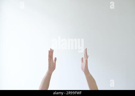 Le mani dell'uomo stanno per posare pregare o adorare qualcosa. Sfondo bianco isolato. Foto Stock