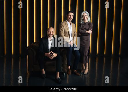 Tre professionisti che sorridono in Dark Office Luxury Interior Foto Stock