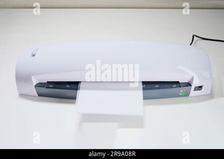 Una macchina per la laminazione di foto e documenti con plastica. Laminatrice bianca da tavolo, primo piano Foto Stock