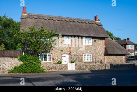 Wistaria Cottage, un vecchio cottage britannico di grado II risalente al XVIII secolo, con tetto in paglia, esterno dipinto in pietra focaia e mattoni. East Preston, Regno Unito. Foto Stock