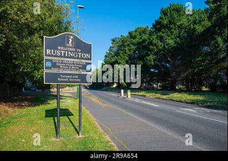 Benvenuti al segno Rustington su una strada principale in Rustington, West Sussex, in Inghilterra, Regno Unito. Foto Stock