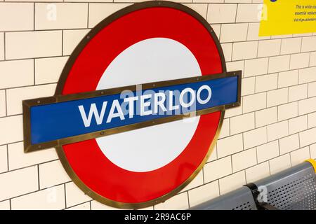 Cartello e logo della stazione della metropolitana di Waterloo sulla parete accanto al binario. Inghilterra, Regno Unito. Concetto: Metropolitana, trasporto per Londra, stazione della metropolitana di Waterloo Foto Stock