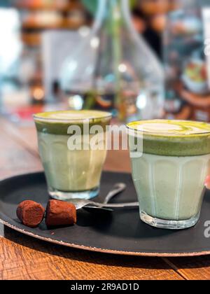 Due tazze di bicchiere di latte matcha su un tavolo di legno Foto Stock